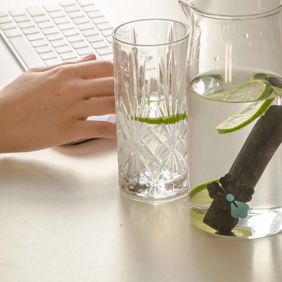 Un Bâton de Charbon Actif Binchotan Taille S (1 Litre) de la marque Kyuké, plongé dans une carafe d'eau