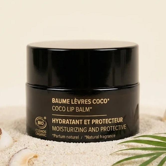 Baume à lèvres coco bio Najel en pot noir sur fond tropical minimaliste avec feuille et texture coco