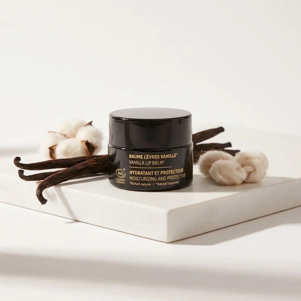 Baume à lèvres vanille bio Najel en pot noir avec étiquette dorée sur fond blanc minimaliste