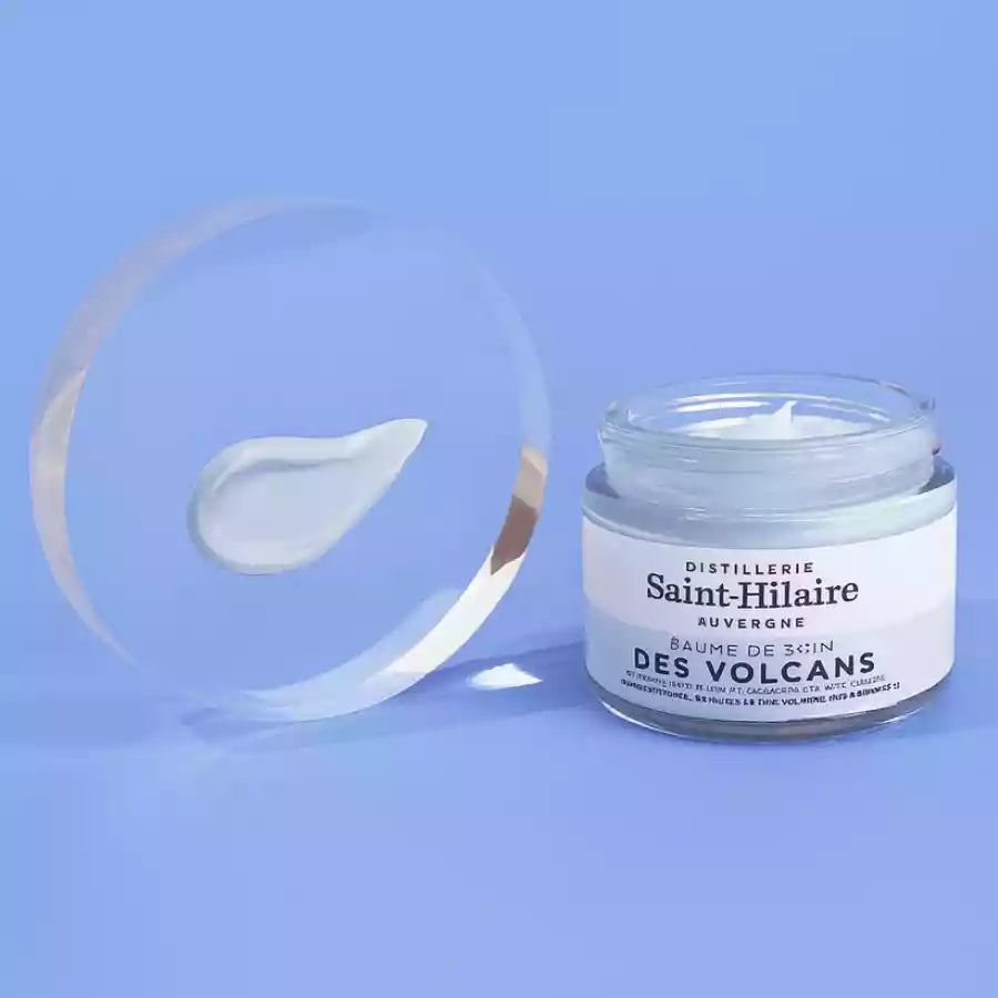 Un baume de soin des volcans avec une goutte de crème sur un disque transparent