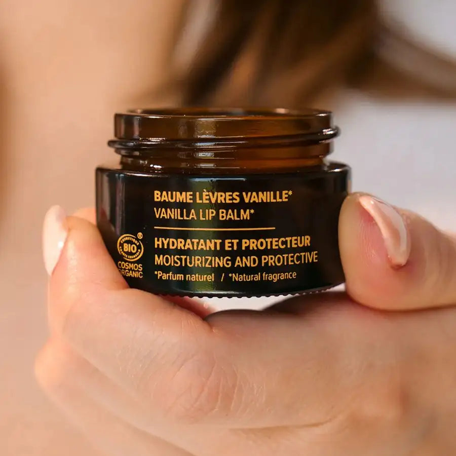 Un Un Baume à Lèvres Vanille Bio de la marque Najel ouvert tenu en main