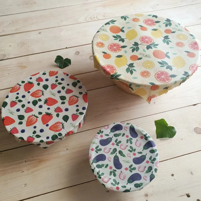 Pack trio des emballages à la cire d'abeille bee wrap de la marque Angie Be Green posés sur une table en bois