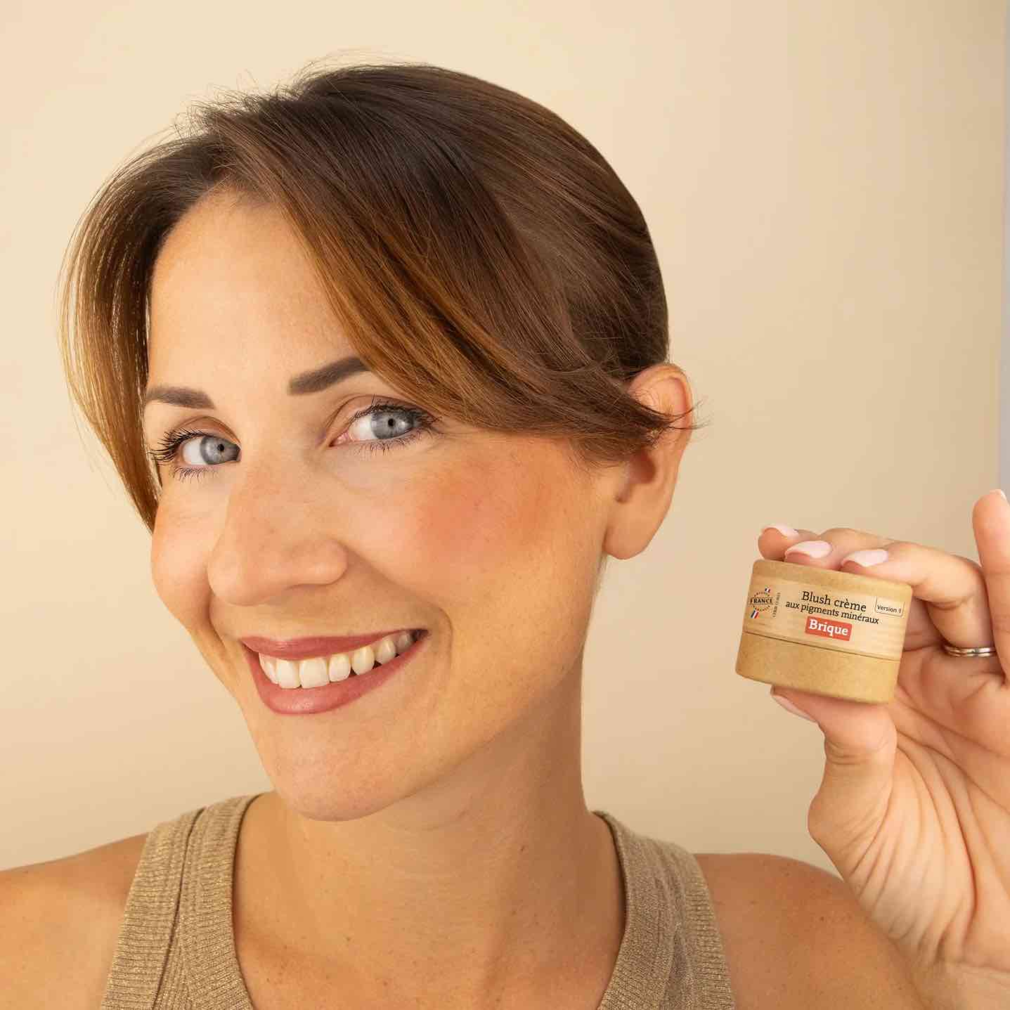 Un blush crème brique appliqué sur les joues d'une femme