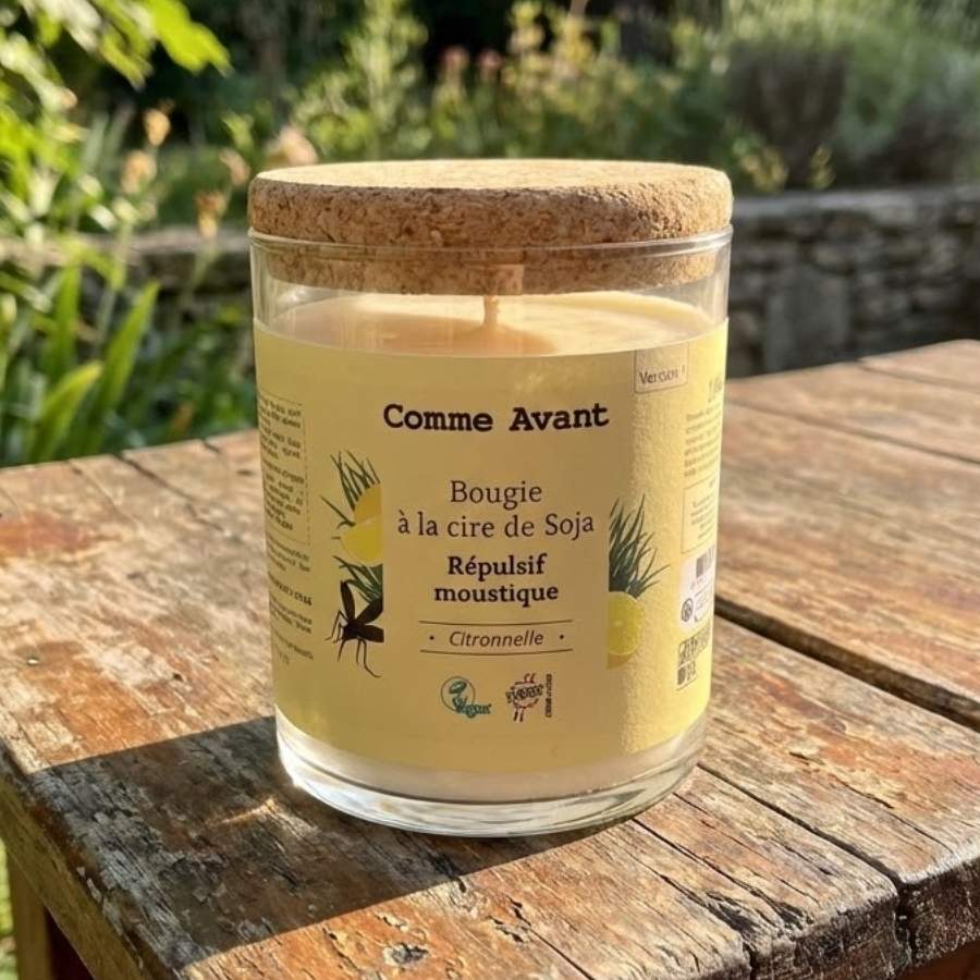 Une Bougie citronelle anti-moustique à la cire de soja Comme Avant posée sur une table en bois à l'extérieur