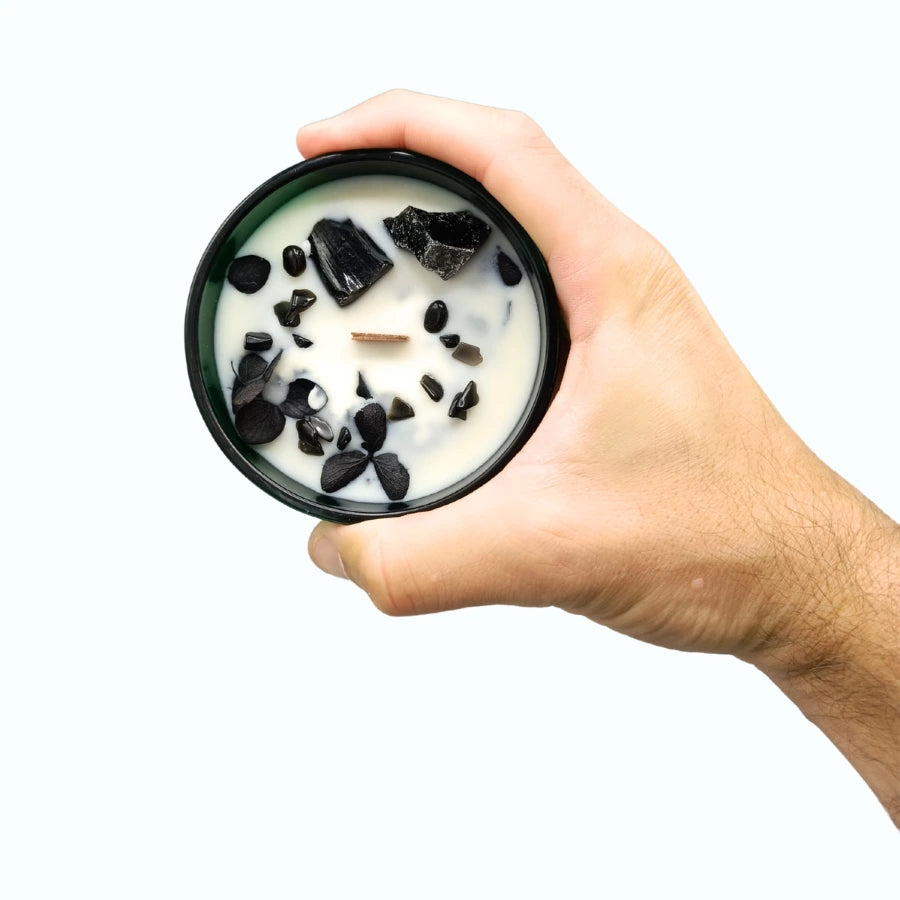 Bougie à la cire de soja fleurs séchées gemme obsidienne tenue dans une main. 