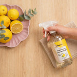 Bouteille spray rechargeable Pimpant citronnelle sur surface bois avec citrons et tissu