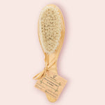 Une Brosse à cheveux Bébé en Bambou - Cap Bambou, sur un fond rose