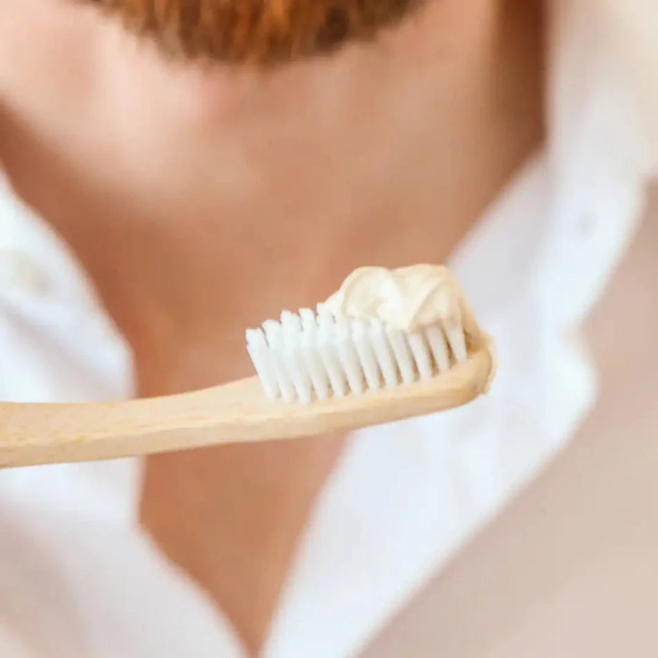 Une brosse à dent en bois avec du dentifrice en pâte