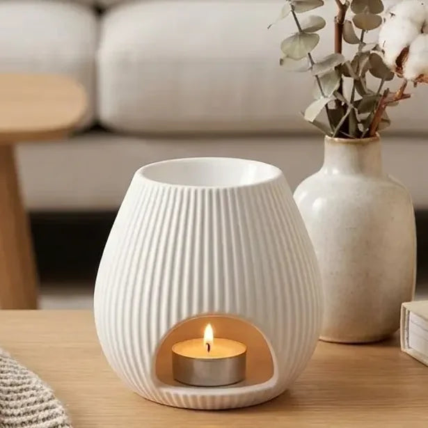 Brûle parfum Scentchips blanc ovale avec bougie allumée dans salon minimaliste