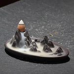 Un brûleur d'encens à reflux "Cascade de montagne" posé sur une table en pierre noire