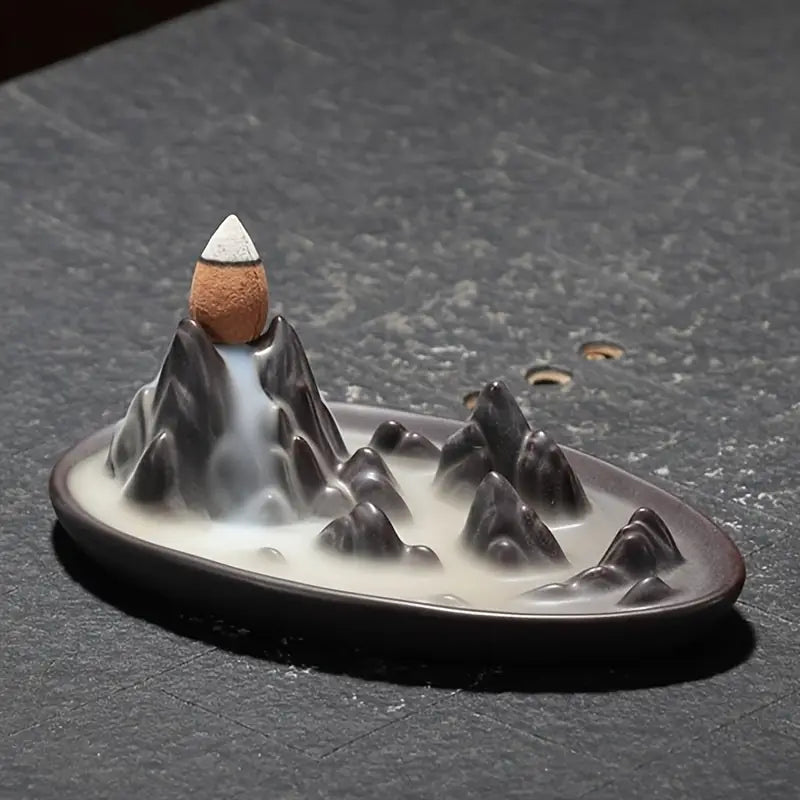 Un brûleur d'encens à reflux "Cascade de montagne" posé sur une table en pierre noire