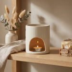 Brûleur de cire blanc cassé en céramique sur étagère scandinave avec fleurs séchées