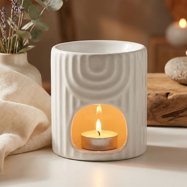 Brûleur de cire blanc en céramique avec bougie allumée et fleurs séchées