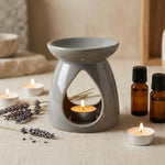 Brûleur de cire grise avec huiles essentielles et lavande sur surface lin