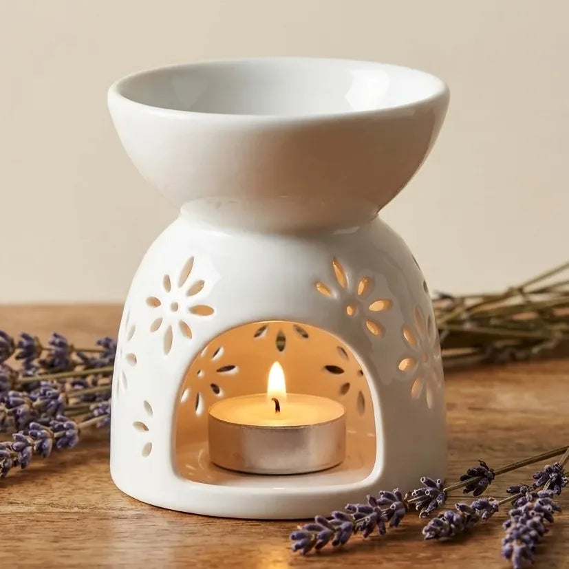 Brûleur de cire en céramique blanc avec motif soleil sur surface en bois