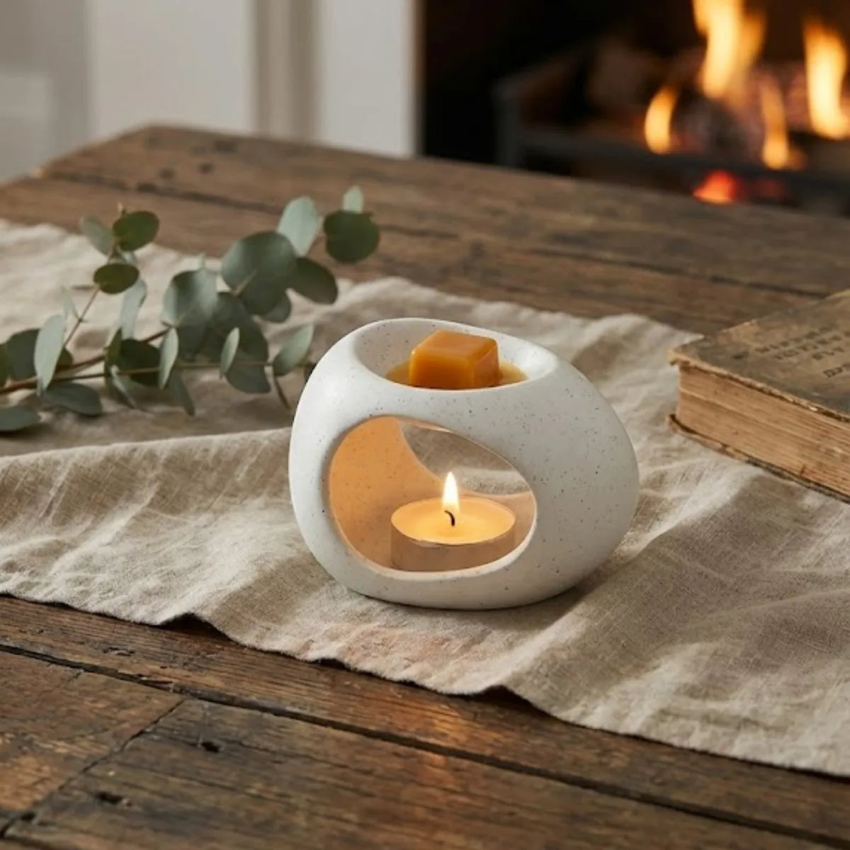 Un diffuseur de parfum naturel pour la maison au design moderne et minimaliste faisant fondre des carrés d'ambre, dans un décor chaleureux