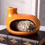 Un Brûleur d'Encens & Palo Santo en Céramique modèle Petite maison orange avec de la sauge à l'intérieur