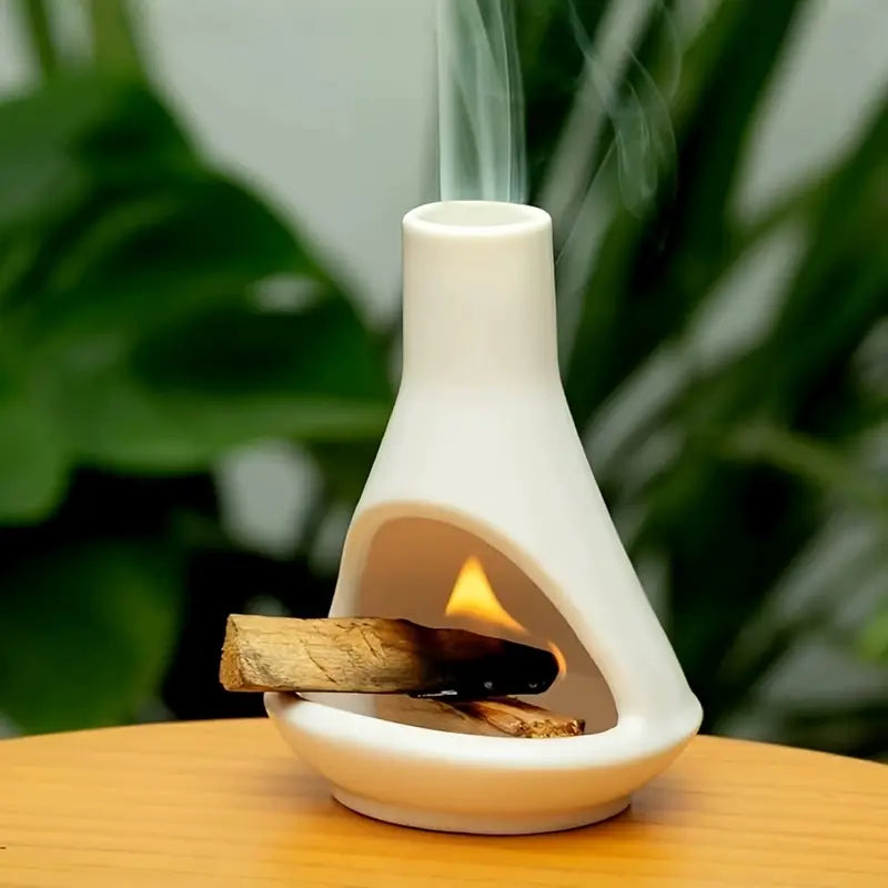 Un Brûleur d'Encens en Porcelaine Blanc avec un baton de palo santo en train de bruler dedans