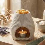 Brûleur Scentchips Flare Désert blanc avec carré d'ambre et bougie allumée dans un décor naturel