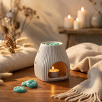 Brûleur Scentchips Flare Désert blanc avec fondants turquoise et bougie allumée sur bois