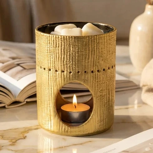 Brûleur Fossil Doré Scentchips avec bougie allumée sur marbre, décoration intérieure luxe