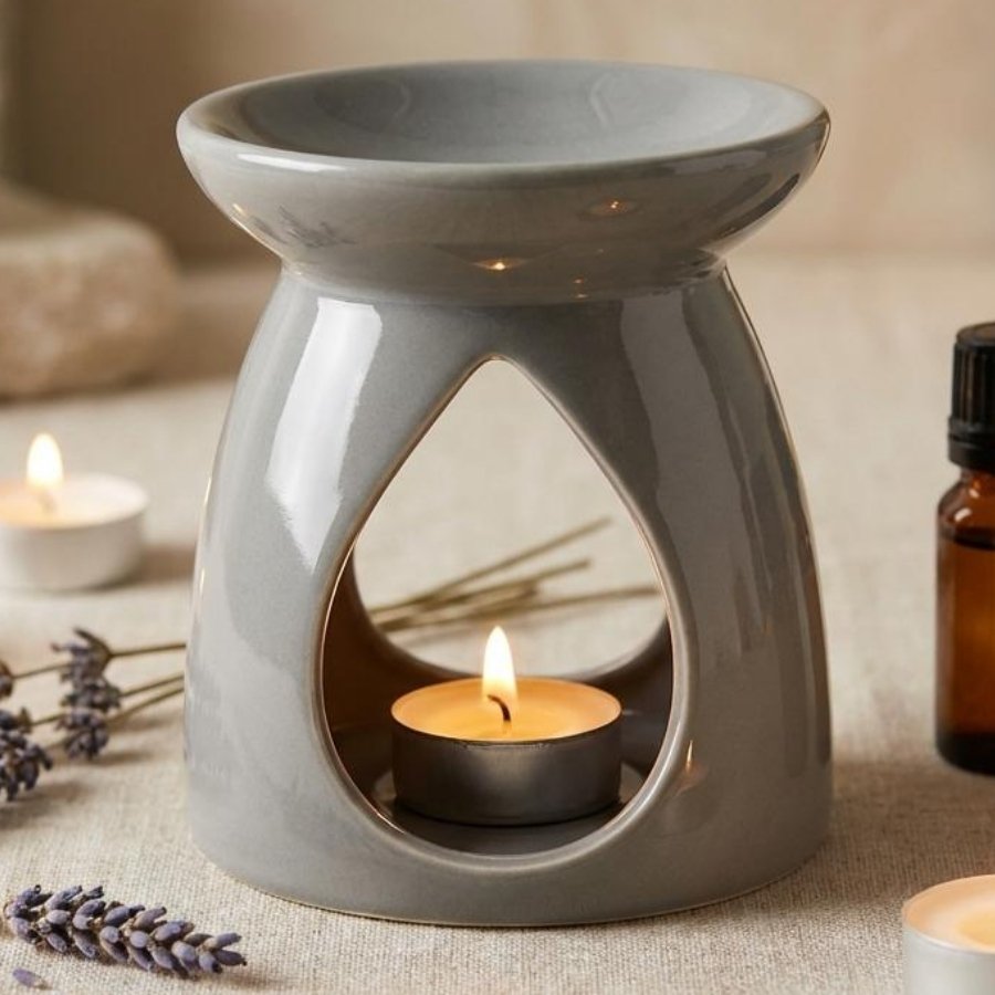 Brûleur de cire grise avec huiles essentielles et lavande sur surface lin