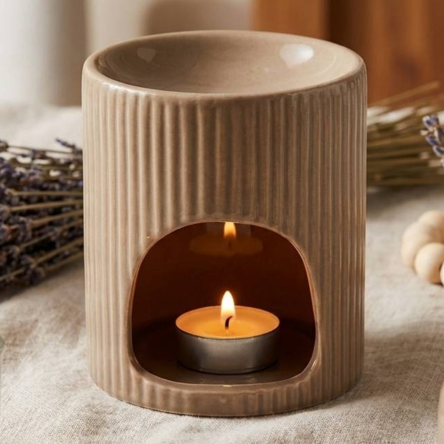 Brûleur de cire taupe avec texture nervurée entouré de lavande séchée et décoration bohème