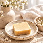 un carré fondant parfum ambre velours dans une coupelle en céramique avec des fleurs