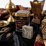 Carré d'Ambre Jamid Musc Noir 30g Hemani avec boîtier doré sur tissu noir