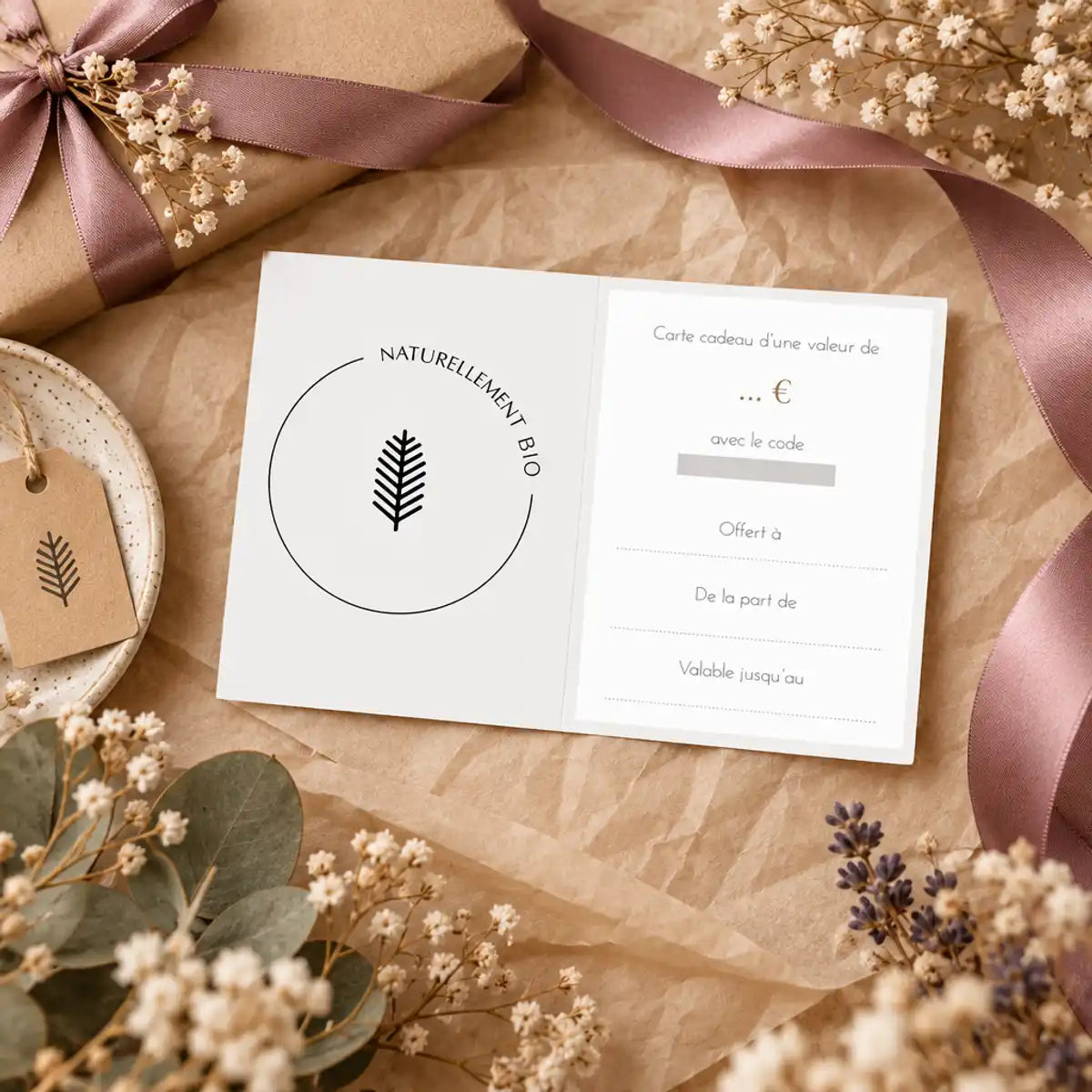 Carte cadeau Naturellement Bio avec logo feuille minimaliste, ruban mauve et fleurs séchées sur kraft