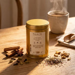 Boîte dorée Chai Maté Bio Place des Thés avec épices et tasse fumante sur bois