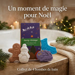 Coffret de 4 bombes de bain Noël Fun Ancient Wisdom, sur un rebord de marbre près d'une baignoire fumante, bougies et guirlandes dorées
