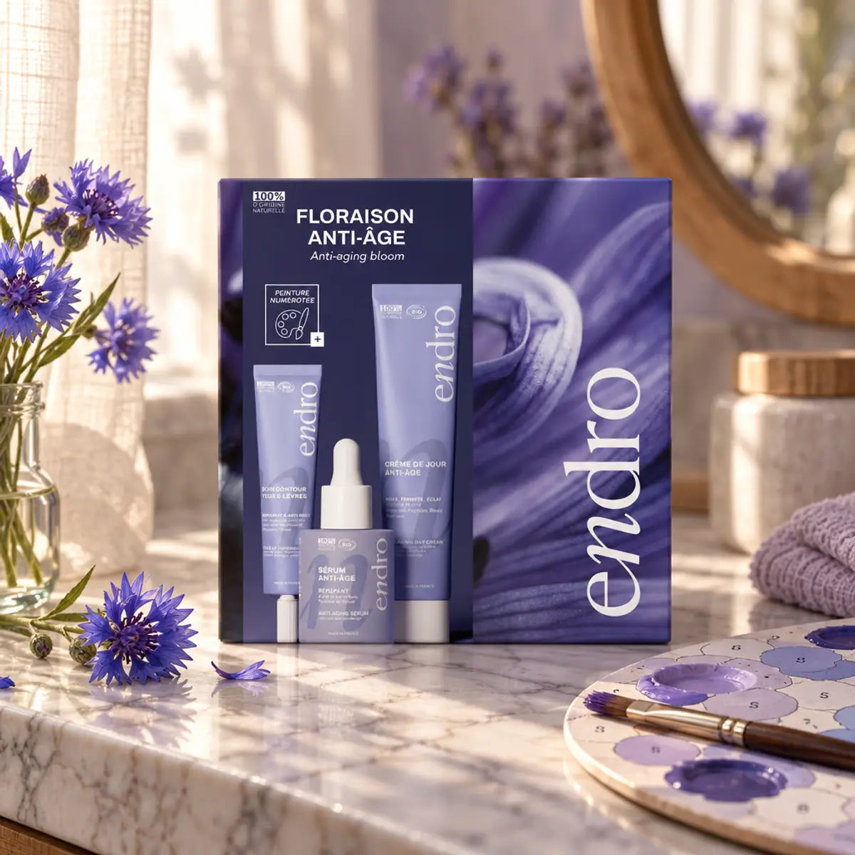 Coffret Floraison Anti-âge bio Endro : contour des yeux, sérum et crème de jour sur marbre, fleurs de bleuet et lumière douce