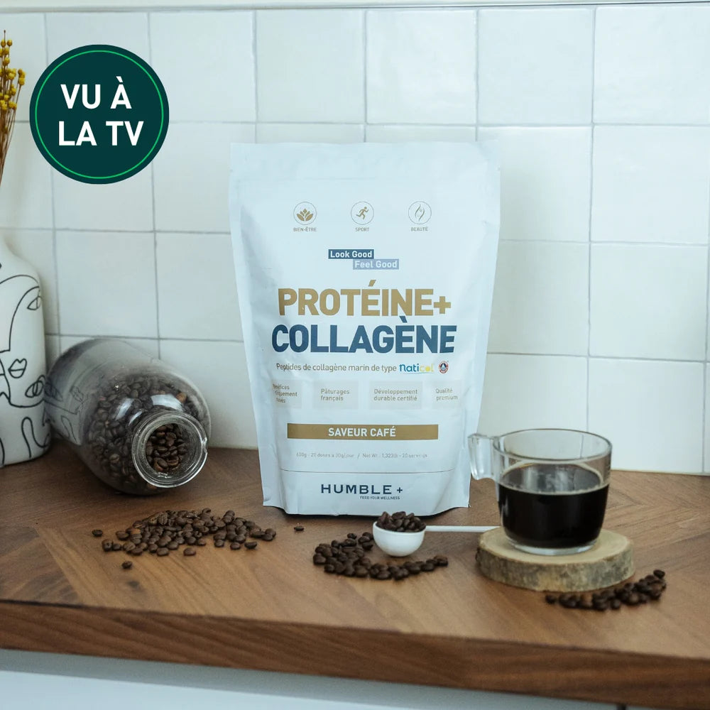 Un sachet de protéines + collagène saveur café Humble+ posé sur un plan de travail avec des grains de café et une tasse de café