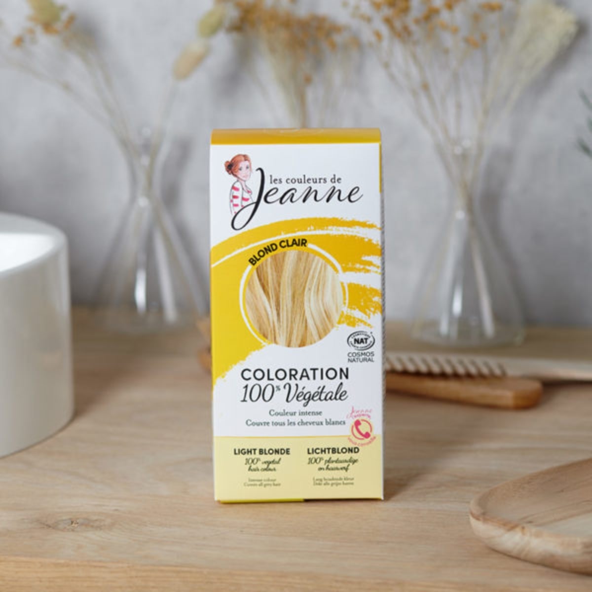 Une boîte de coloration blond clair les couleurs de jeanne posée sur un plan de travail dans une salle de bain