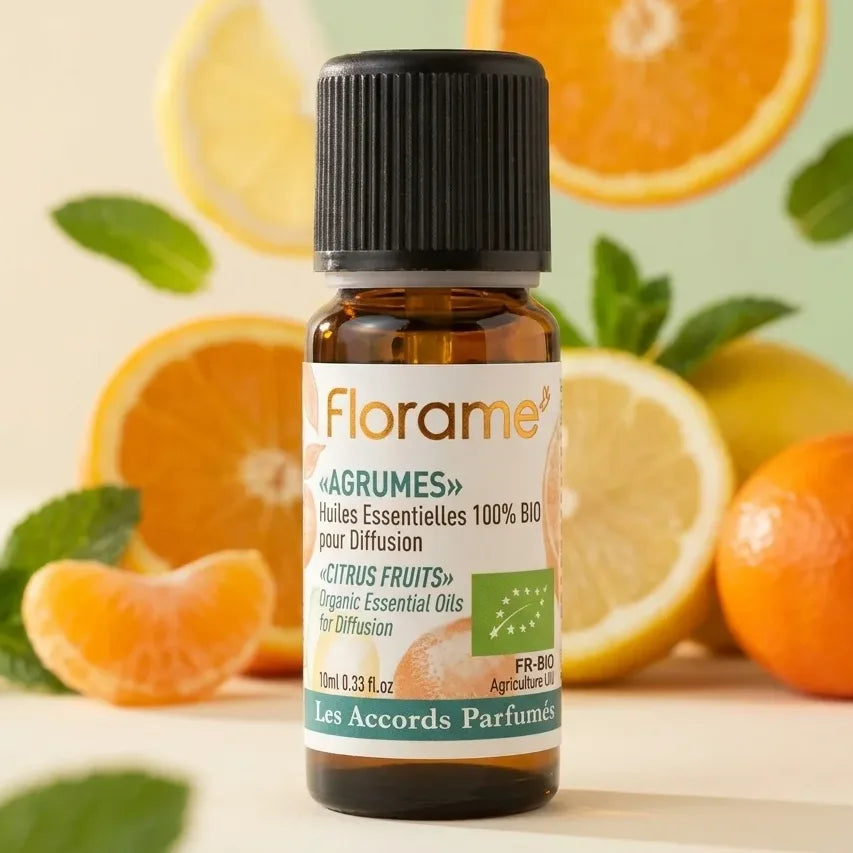 Flacon d'huile essentielle Agrumes Bio Florame 10ml avec agrumes frais et feuilles de menthe