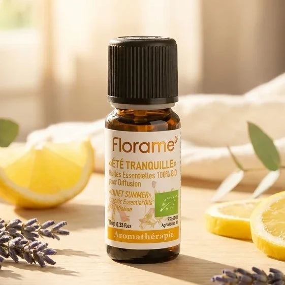 Flacon d'huile essentielle Été Tranquille Citronnelle Bio Florame 10ml entouré de citron frais et lavande