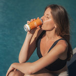 Créatine Water Humble+ 330ml consommé par une femme au bord d'une piscine