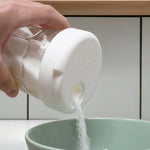 Pot avec son couvercle verseur universel blanc Anotherway qui verse du sucre