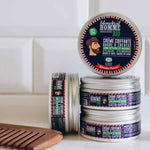 plusieurs pots de crème coiffante posé avec un peigne en bois