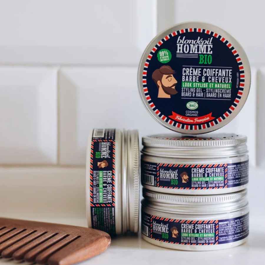 plusieurs pots de crème coiffante posé avec un peigne en bois