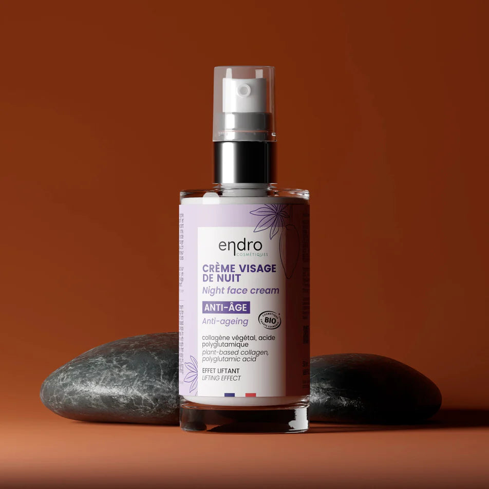 Une crème de nuit pour le visage anti-âge de la marque Endro posée à côté de deux galets gris