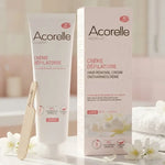 Crème dépilatoire Acorelle 150ml sur vanité avec spatule et fleurs blanches