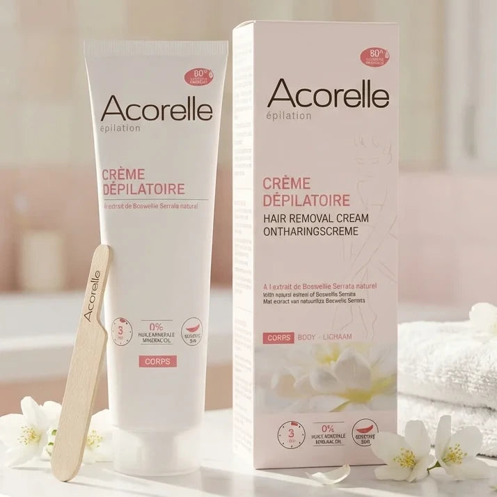 Crème dépilatoire Acorelle 150ml sur vanité avec spatule et fleurs blanches