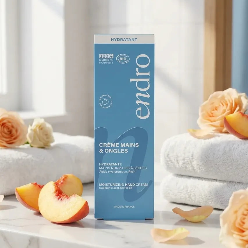 Crème hydratante mains Endro 50 mL bleu sur marbre avec fleurs et pêches