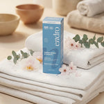 Crème hydratante mains Endro 50ml emballage bleu sur fond spa blanc avec fleurs et gouttes d'eau
