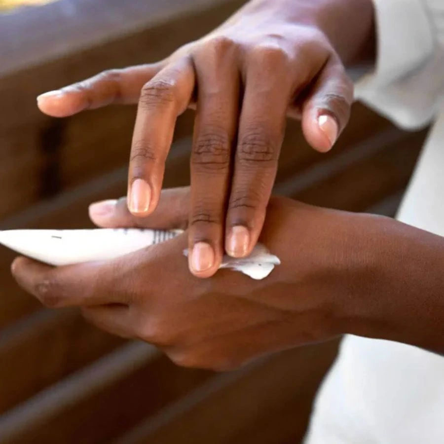Une femme s'appliuant de la crème sur les mains