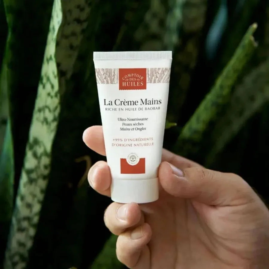 Un tube de crème mains et ongles de la marque Comptoir des huiles en 50 ml tenu dans une main