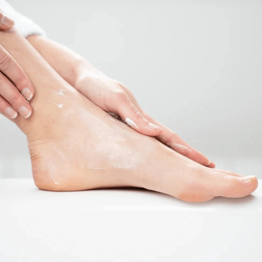 une femme se massant le pied avec de la crème nutri-réparatrice endro sur son pied
