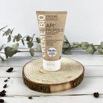 Photo d'ambiance d'Un tube de crème Propolis bio de 100 ml de la marque Propos’Nature posé sur une rondin de bois